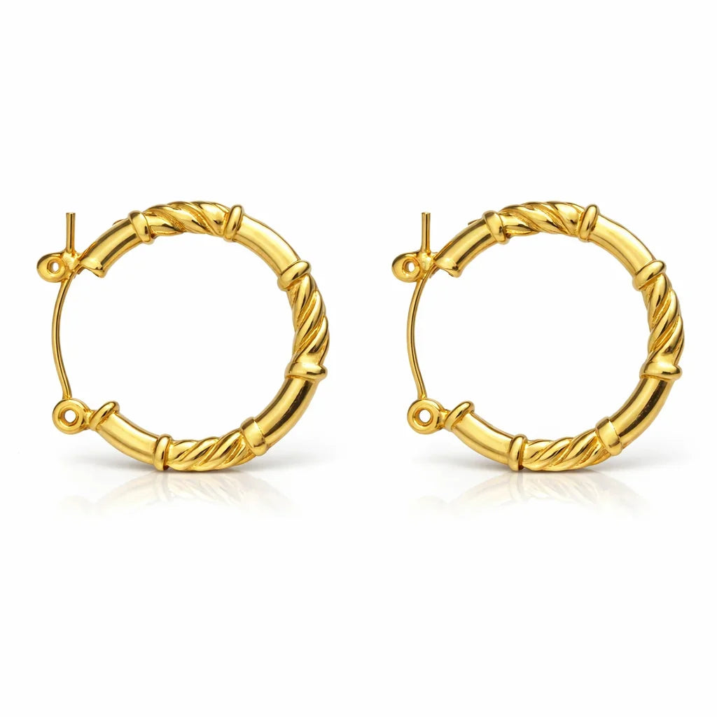 Gold-tone twisted hoop earrings with textured bamboo-inspired design on white background