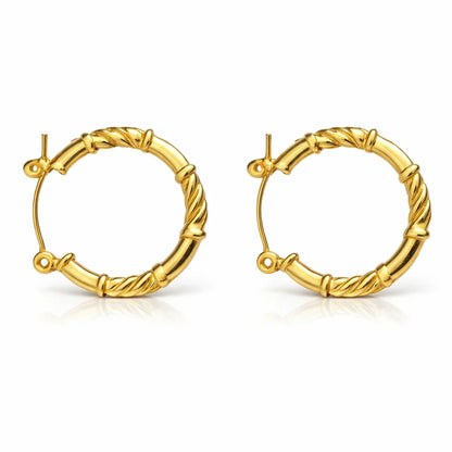 Gold-tone twisted hoop earrings with textured bamboo-inspired design on white background