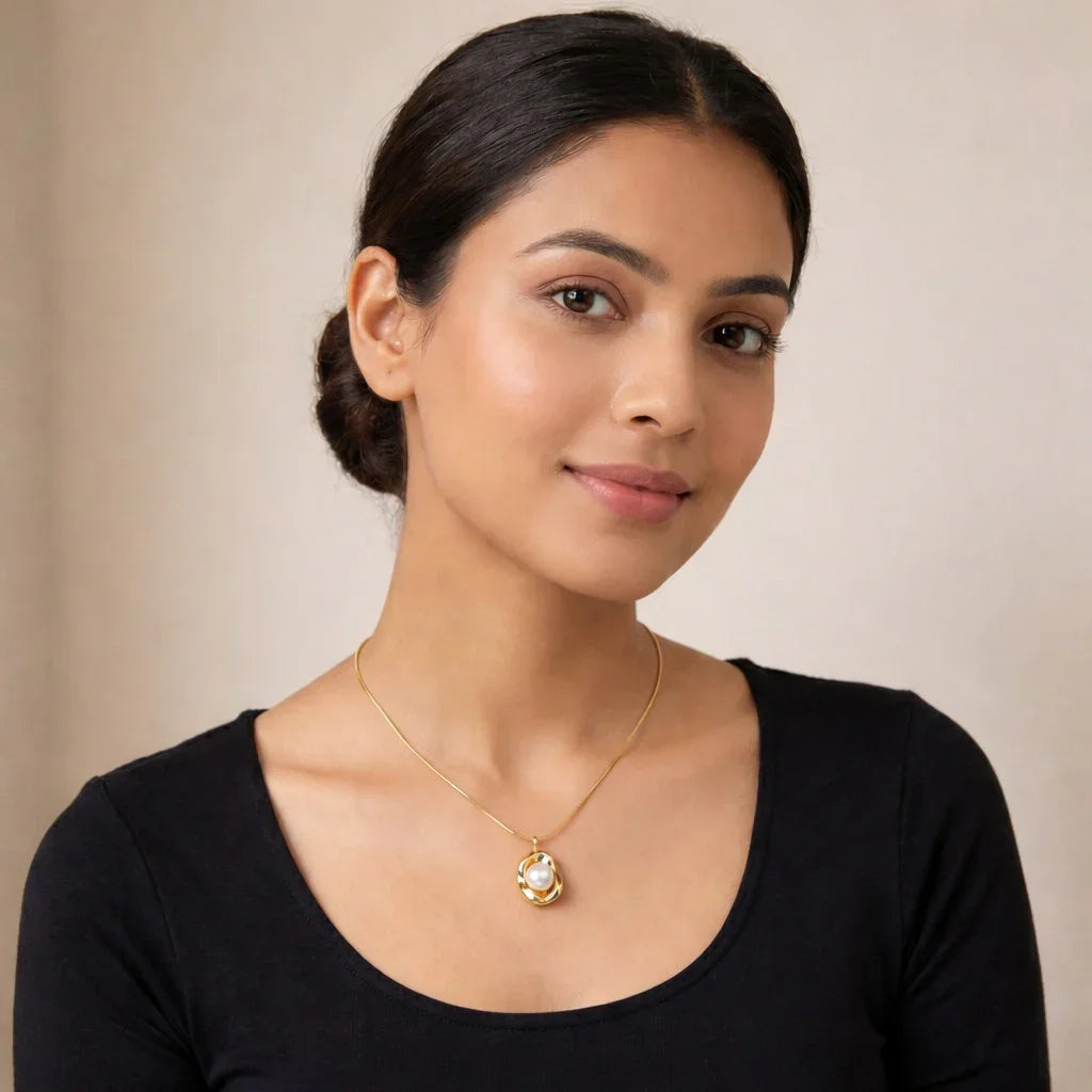 Woman wearing a gold minimalist necklace with a pearl pendant, showcased against a neutral background.
