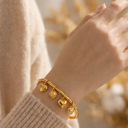 Gold stainless steel bracelet with heart charms on wrist, minimalist jewelry style